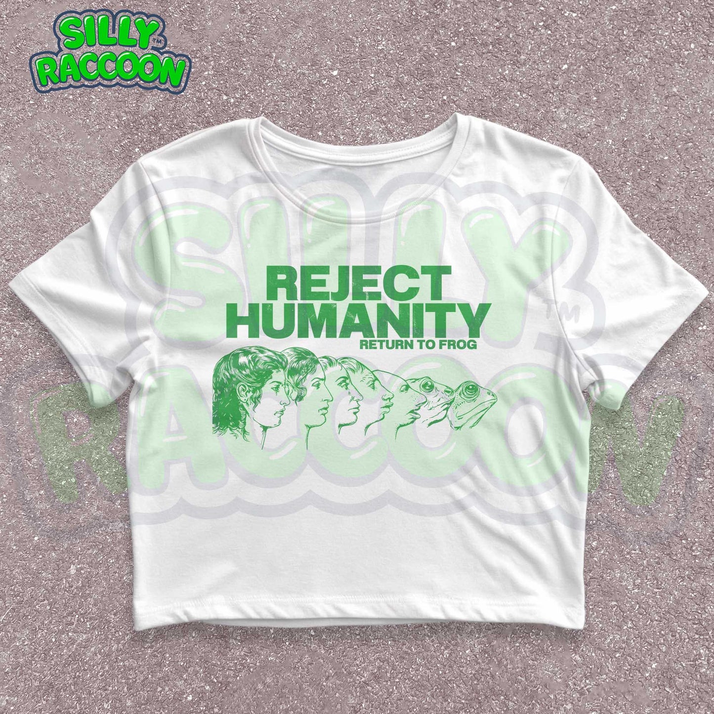 Young woman wearing a white Y2K baby tee, perfect for Gen Z fashion lovers and teens into alt clothing. The shirt features a green graphic print with the text "REJECT HUMANITY RETURN TO FROG" and an illustration showing human faces morphing into frogs. This funny meme shirt taps into internet culture and weirdcore aesthetic. It's a great sarcastic gift for anti-social friends or any frog lover. Ideal casual wear top, this graphic tee suits everyday outfits or alternative style look