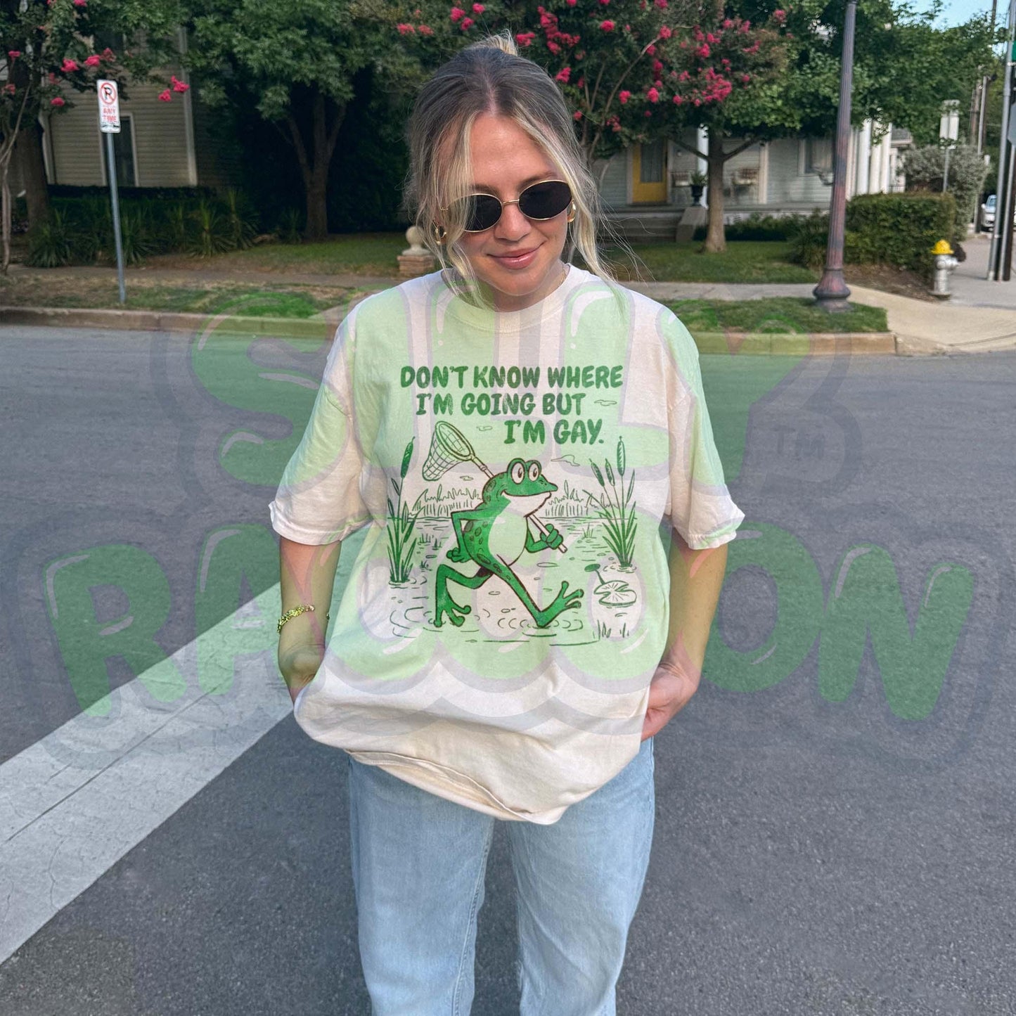Funny Gay Frog Shirt for men and women featuring a green cartoon frog walking through a marsh carrying a butterfly net over its shoulder. Above the frog, the text reads "DON'T KNOW WHERE I'M GOING BUT I'M GAY" in bold green font. The illustration has a vintage, slightly distressed graphic tee style. This unisex LGBTQ pride t-shirt is a humorous gift for gay friends, perfect for Pride Month or as a coming out gift.
