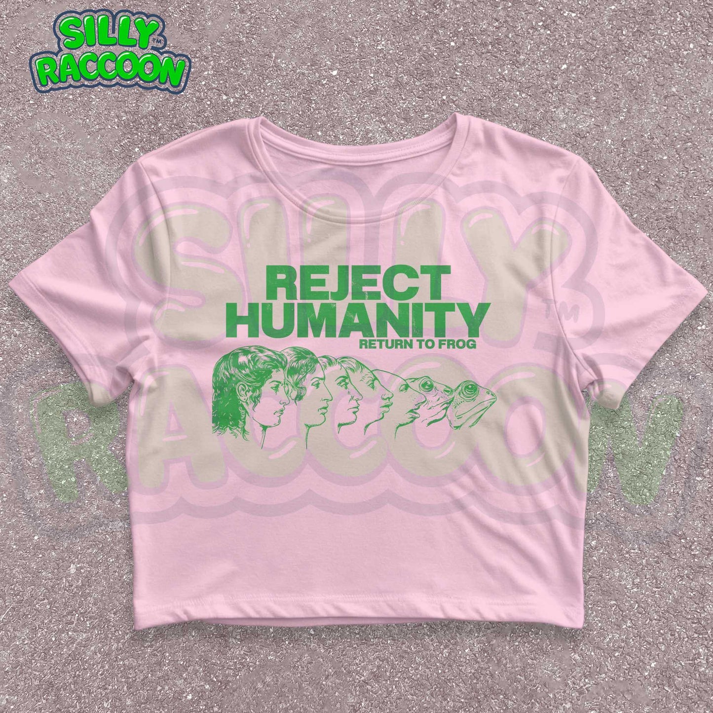 Young woman wearing a white Y2K baby tee, perfect for Gen Z fashion lovers and teens into alt clothing. The shirt features a green graphic print with the text "REJECT HUMANITY RETURN TO FROG" and an illustration showing human faces morphing into frogs. This funny meme shirt taps into internet culture and weirdcore aesthetic. It's a great sarcastic gift for anti-social friends or any frog lover. Ideal casual wear top, this graphic tee suits everyday outfits or alternative style look