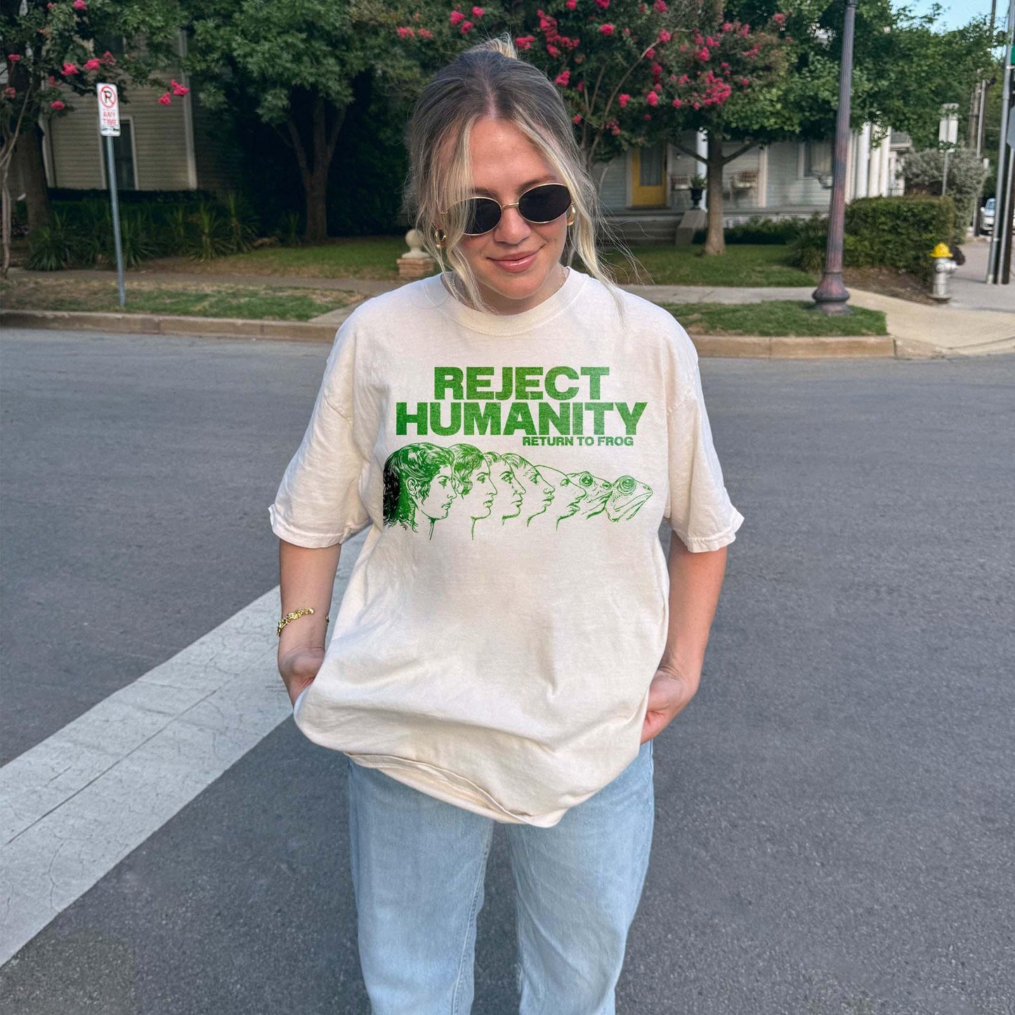 Unisex t-shirt for Gen Z featuring the text "Reject Humanity Return to Frog" in green with an illustrated human-to-frog evolution graphic. Perfect for fans of meme humor, absurdist internet culture, and ironic fashion. Retro Y2K style with soft fabric feel. Great gift idea for frog lovers, internet meme fans, or anyone into weird aesthetics and frogcore vibes.