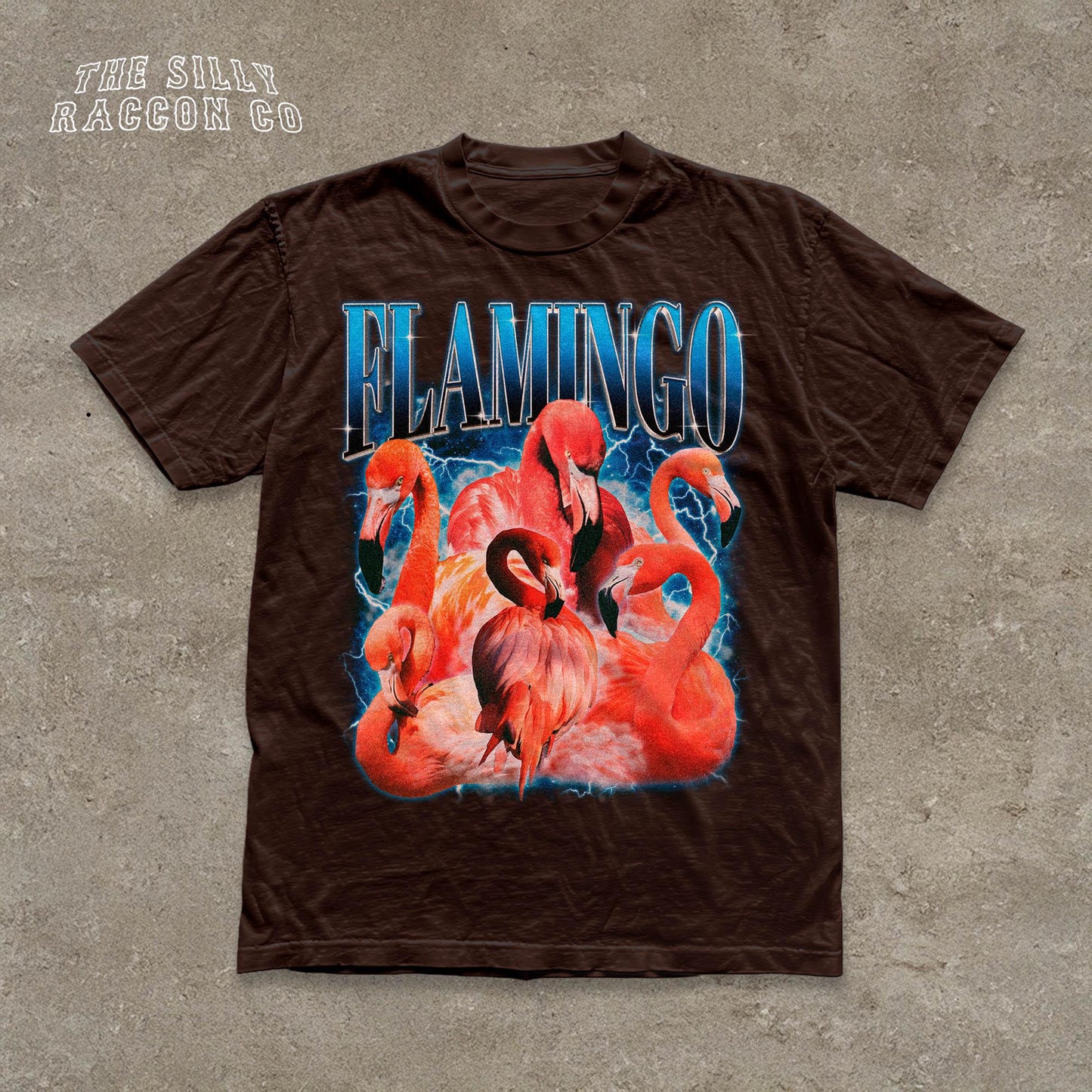 A brown t-shirt with a graphic design featuring a group of flamingos against a blue background.
