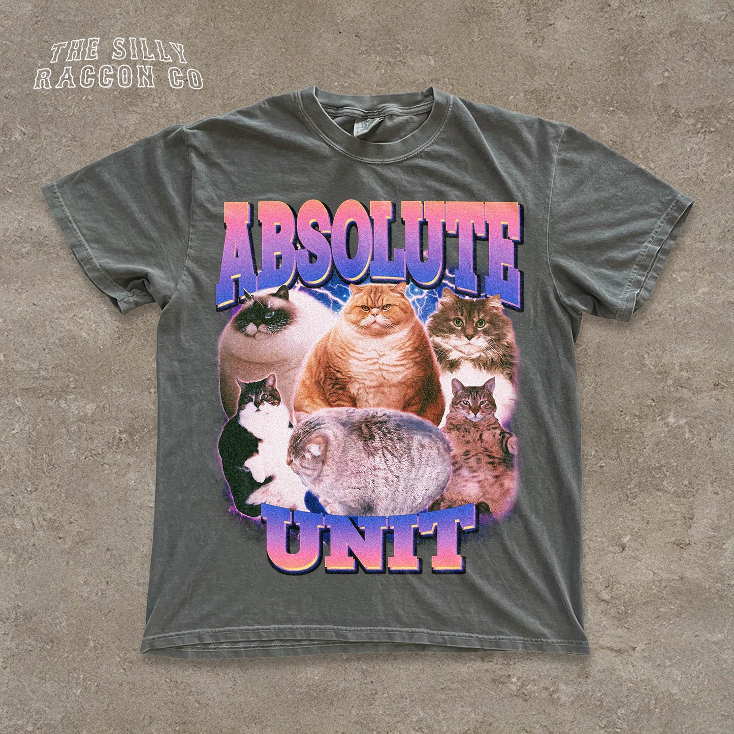The image is a t-shirt design featuring a collage of various cats, including a large cat and several smaller cats, all sitting together. The text on the t-shirt reads "ABSOLUTE UNIT".