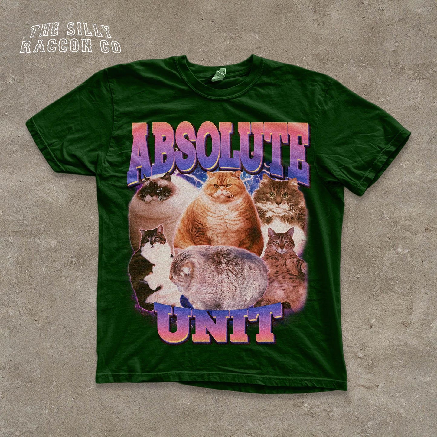The image is a green t-shirt with a graphic design featuring a group of cats, including a large cat in the center surrounded by smaller cats.