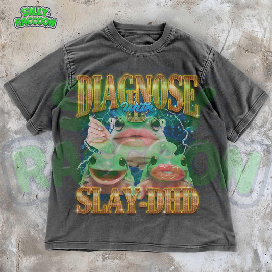 Trendy ADHD T-shirt for teens & adults. Features playful frogs with red lips, gold &quot;DIAGNOSE with SLAY-DHD&quot; text, lightning, and pop art style. Perfect for casual wear, mental health advocacy, or fun gifts. Vibrant, empowering design on a black streetwear tee.