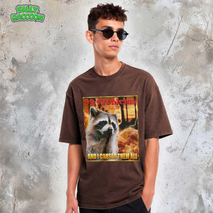 This Comfort Colors t-shirt features a funny raccoon meme design perfect for women and men who love weird, sarcastic humor. The retro-style graphic on this unisex tee shows a raccoon looking guilty with the text &quot;99 Problems AND I CAUSED THEM ALL,&quot; ideal for casual wear or as a gag gift for a friend who appreciates ironic, unhinged shirts and possum-themed humor.