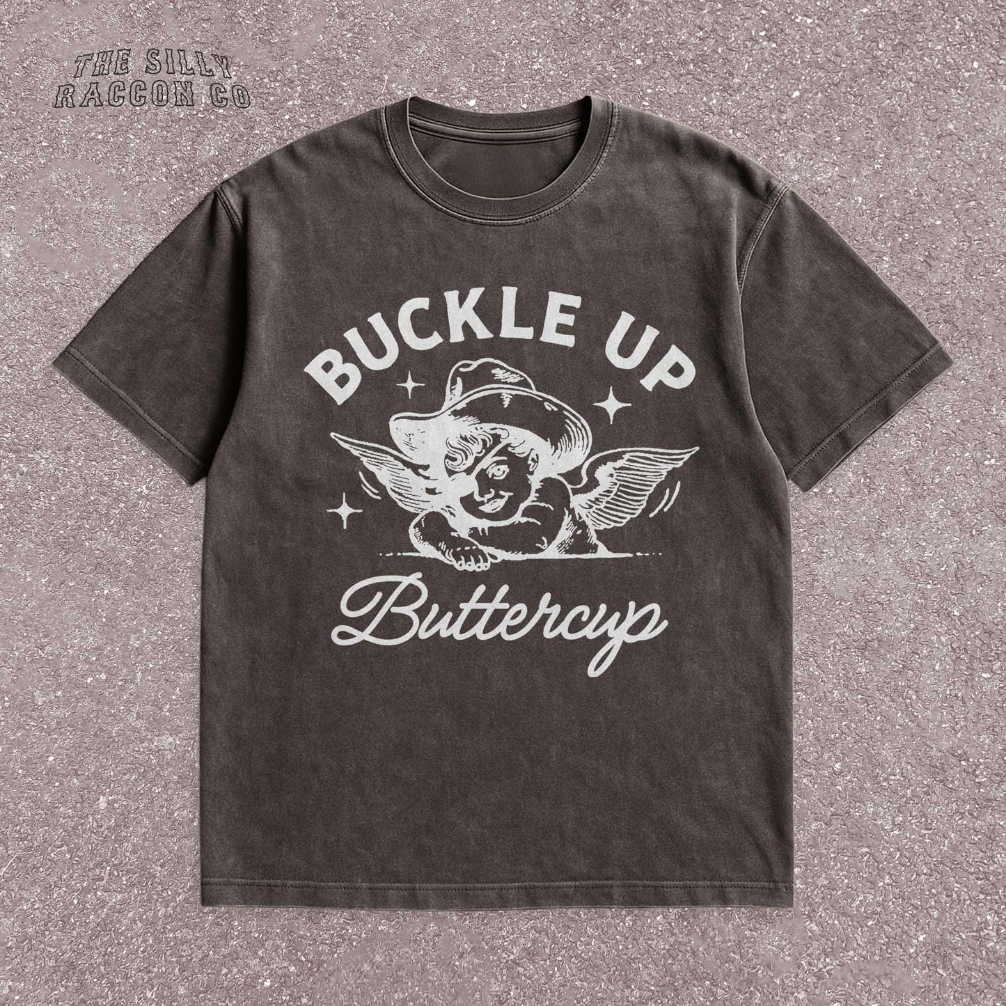 Funny western shirt for women featuring a vintage cowboy angel with wings and the quote &quot;Buckle Up Buttercup&quot; in bold retro typography. The design blends southern sass with angelcore and rodeo aesthetics, perfect for cowgirl fashion or western gifts. Great as a vintage graphic tee with humor and charm for her, ideal for gifting or personal style with a nostalgic Y2K vibe.