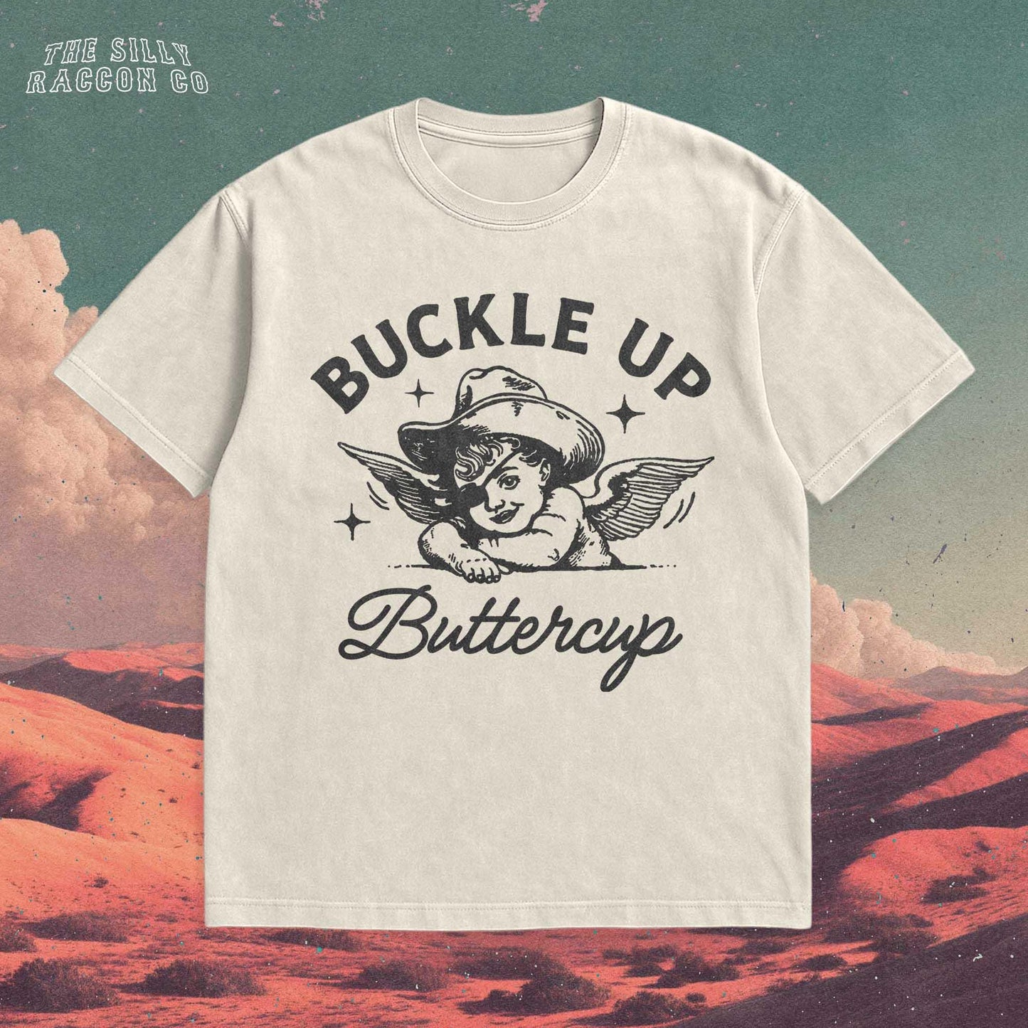 Funny western shirt for women featuring a vintage cowboy angel with wings and the quote &quot;Buckle Up Buttercup&quot; in bold retro typography. The design blends southern sass with angelcore and rodeo aesthetics, perfect for cowgirl fashion or western gifts. Great as a vintage graphic tee with humor and charm for her, ideal for gifting or personal style with a nostalgic Y2K vibe.