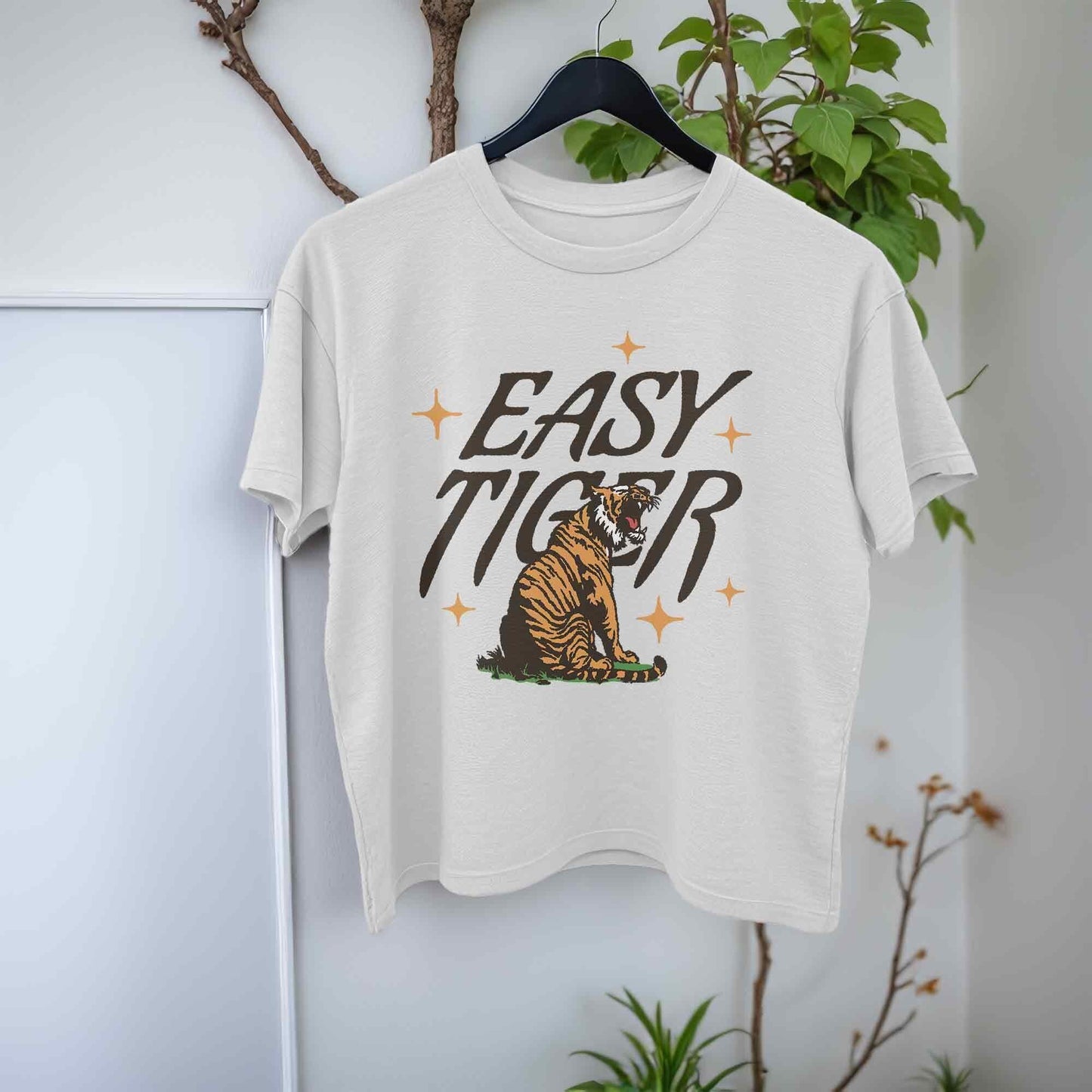 White crop top t-shirt featuring a playful retro-style graphic of a tiger with the text Easy Tiger.