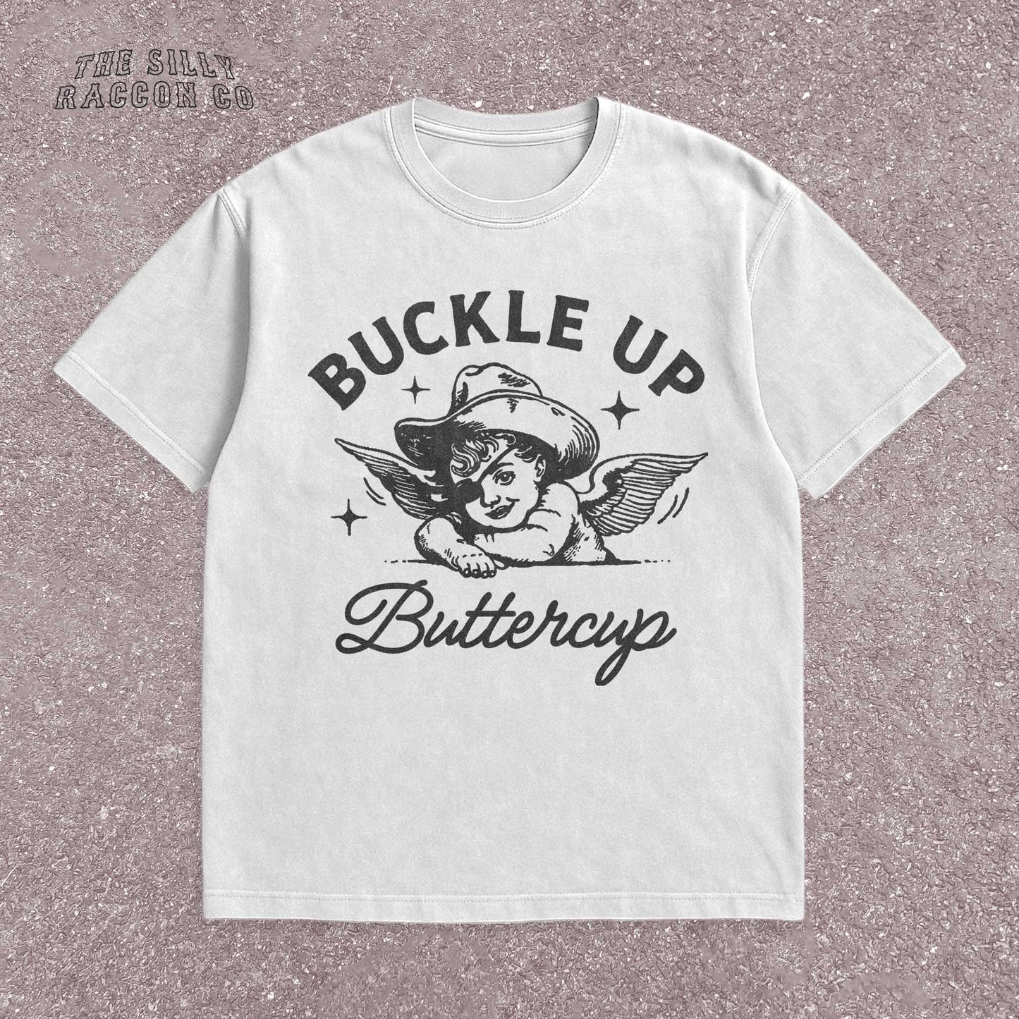 Funny western shirt for women featuring a vintage cowboy angel with wings and the quote &quot;Buckle Up Buttercup&quot; in bold retro typography. The design blends southern sass with angelcore and rodeo aesthetics, perfect for cowgirl fashion or western gifts. Great as a vintage graphic tee with humor and charm for her, ideal for gifting or personal style with a nostalgic Y2K vibe.