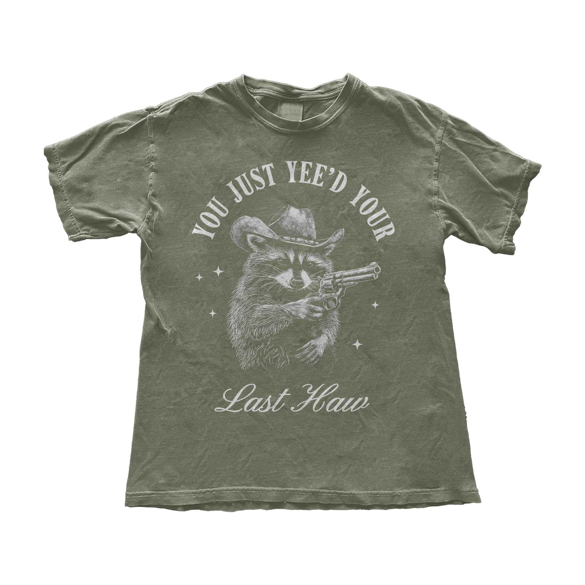 Funny cowboy raccoon t-shirt featuring a vintage-style hand-drawn raccoon in a cowboy hat holding a revolver. This Western humor graphic tee is perfect for country lovers, rodeo fans, and meme enthusiasts. Designed for men and women who love Southern slang, Wild West culture, and outlaw aesthetics. Great for casual wear, cowboy-themed parties, or as a hilarious gift for raccoon lovers and Western humor fans.