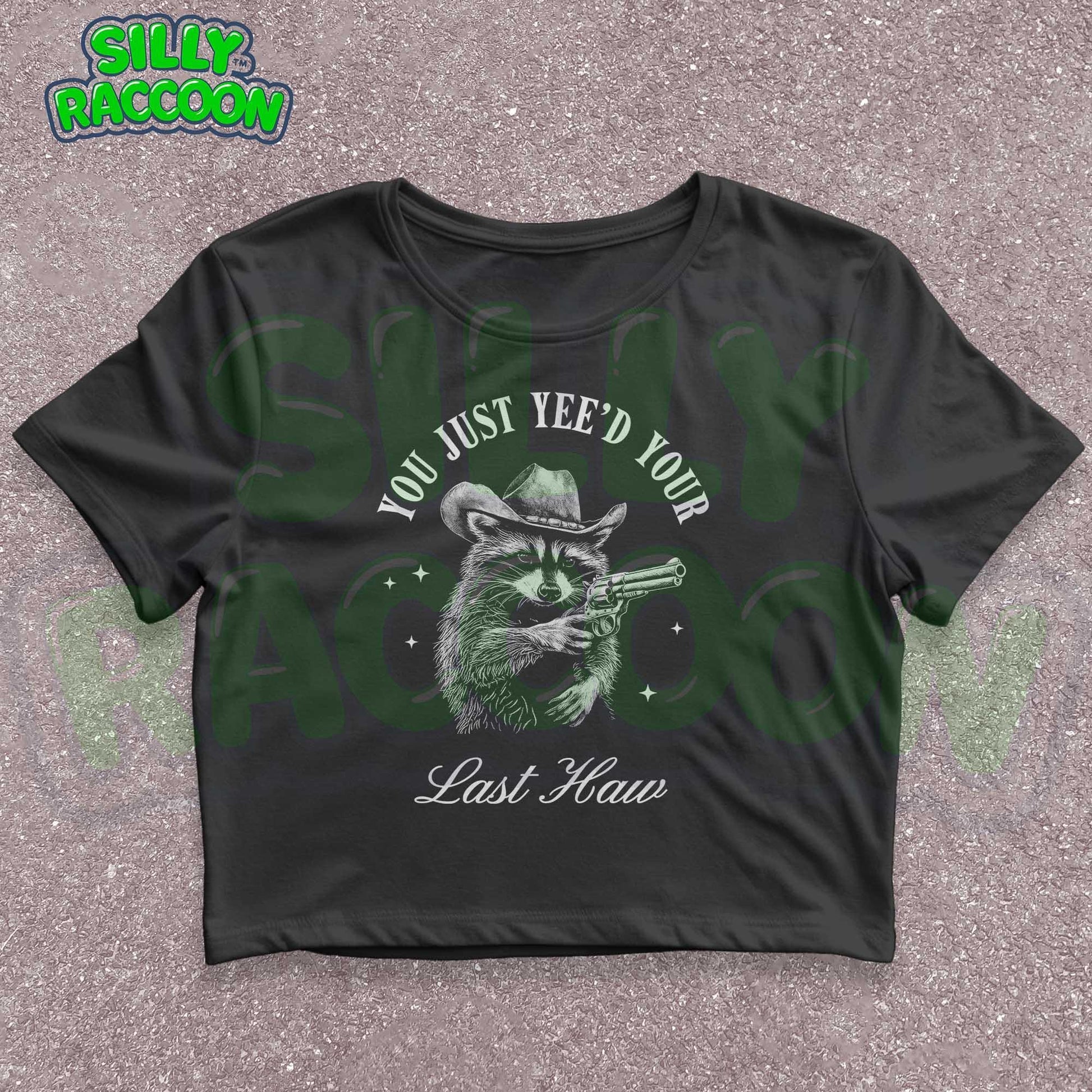 Funny western crop top for women featuring a detailed sketch of a raccoon wearing a cowboy hat and aiming a pistol. The text &quot;You Just Yee&#39;d Your Last Haw&quot; surrounds the raccoon graphic. This humorous graphic tee blends country and meme culture, perfect for young adults and women who love sarcastic animal shirts. Ideal gift for country girls, raccoon lovers, or anyone who enjoys funny southern sayings and western meme apparel.