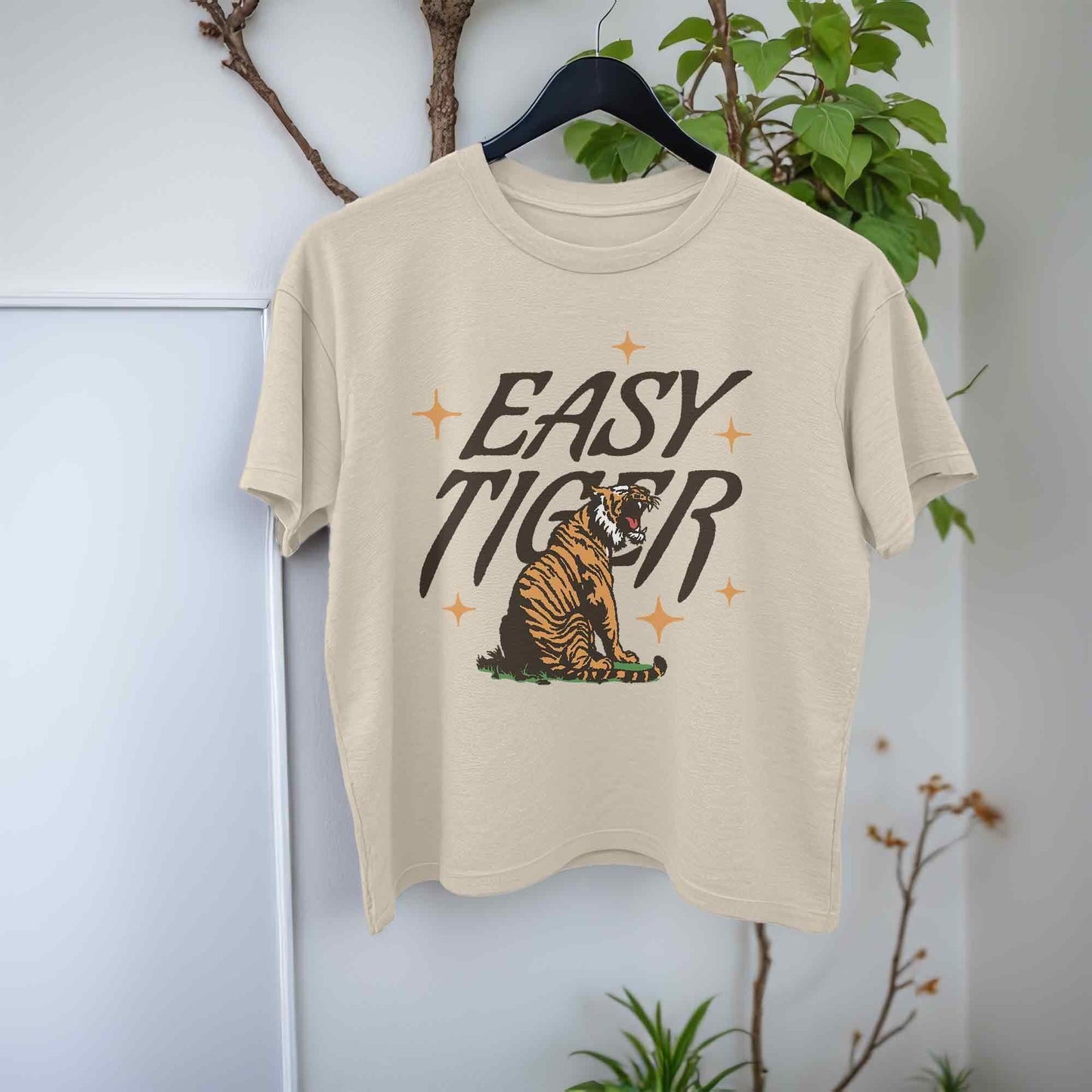 beige crop top t-shirt featuring a playful retro-style graphic of a tiger with the text Easy Tiger.